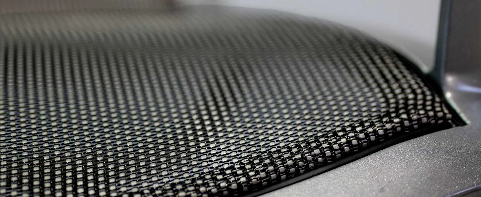 Close-up of black mesh sling fabric on a chair seat