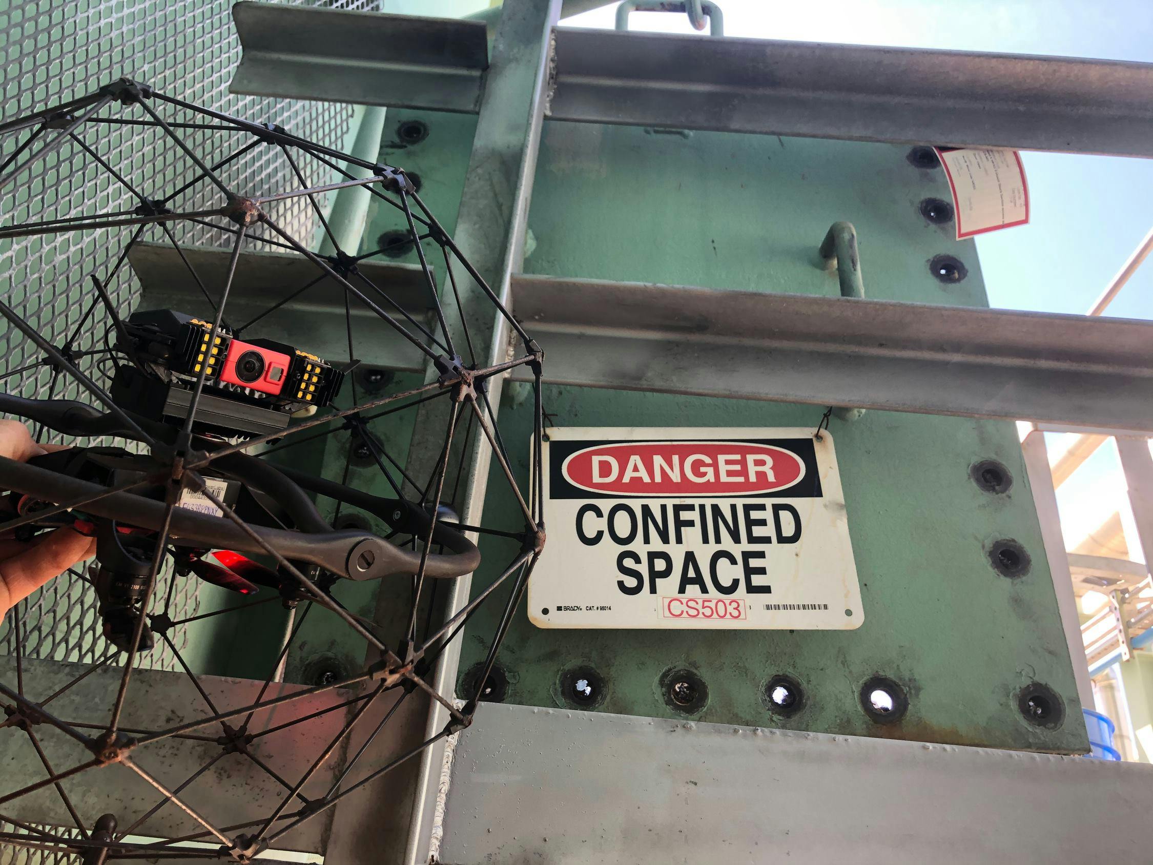 Elios drone next to a sign that says &quot;danger - confined space&quot;