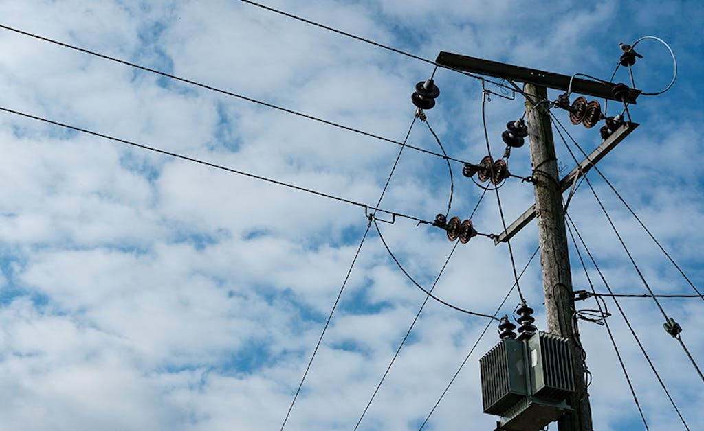 Detailed view of a high power electrical cabling system seen atop a utility pole.