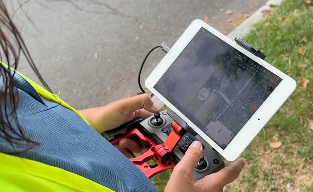 drone operator controls her drone interface during electric inspection.