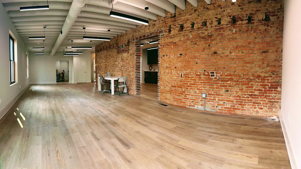 The Media Proper office at 20 W. 3rd Street after the rebuild: exposed brick, new floors, linear lighting