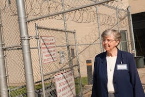 Sister Mary Elizabeth Killoran standing in front of Howard R. Young Prison.
