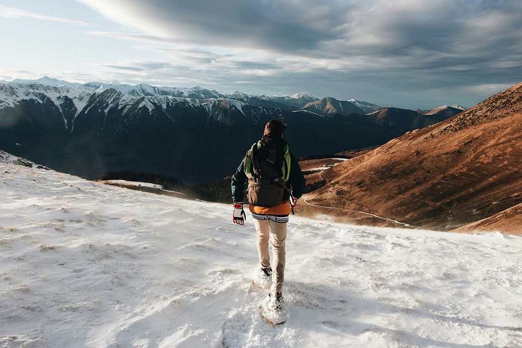 a person walking on a snowed mountain hill