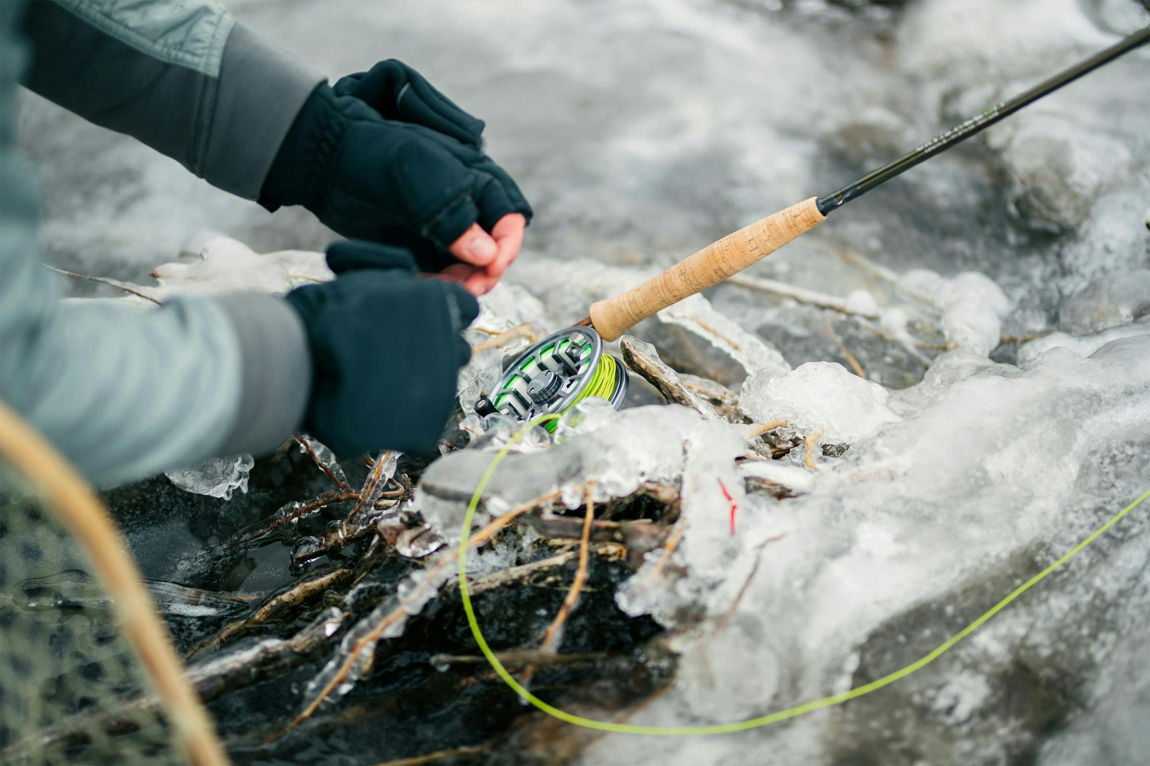 ice fisherman tying a lure