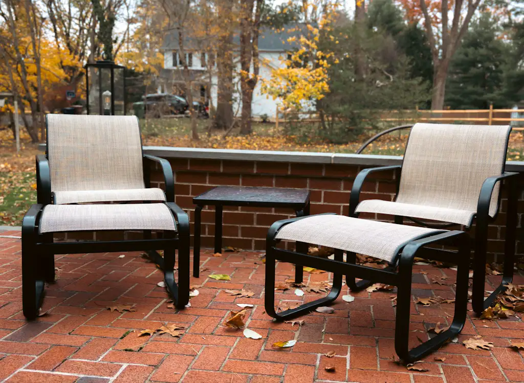 Restored sling lounge chairs and ottomans on a brick patio