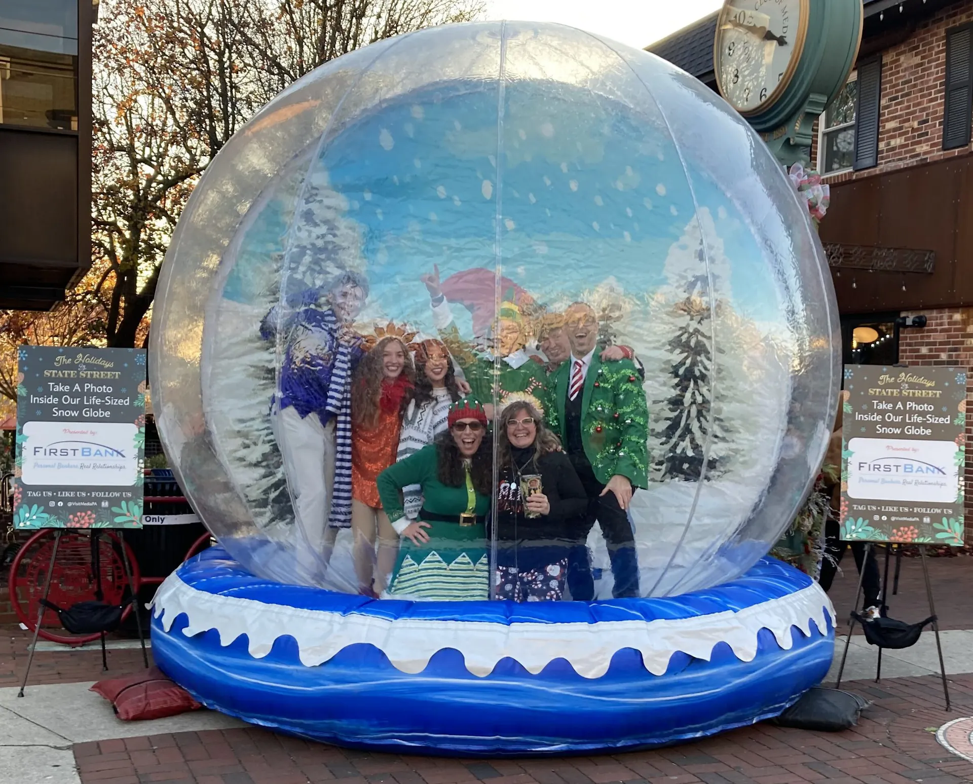 Visitors posing inside a giant snow globe on State Street